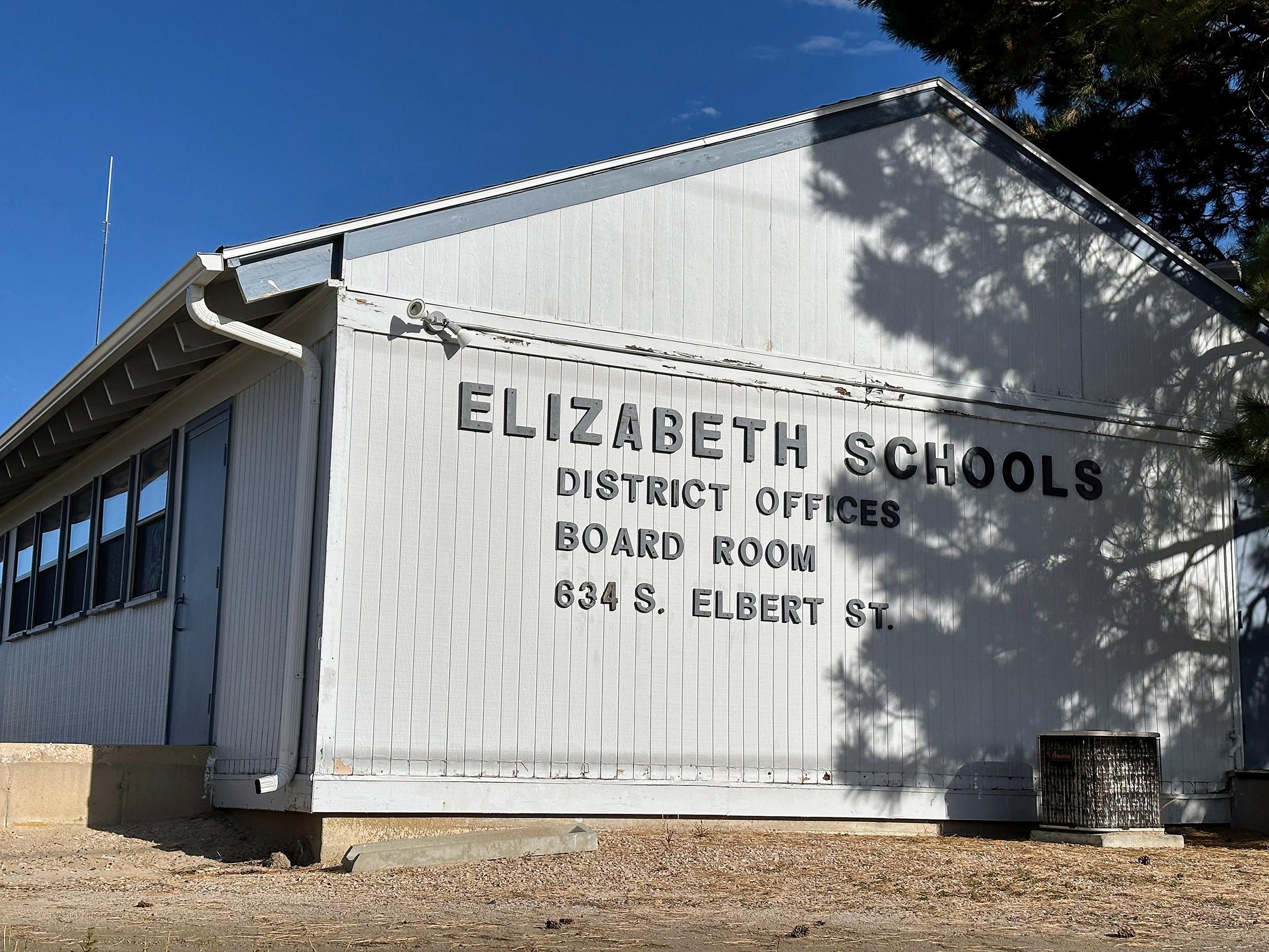 The side of a white paneled building that says Elizabeth Schools District Offices, Board Room, 634 S. Elbert St.