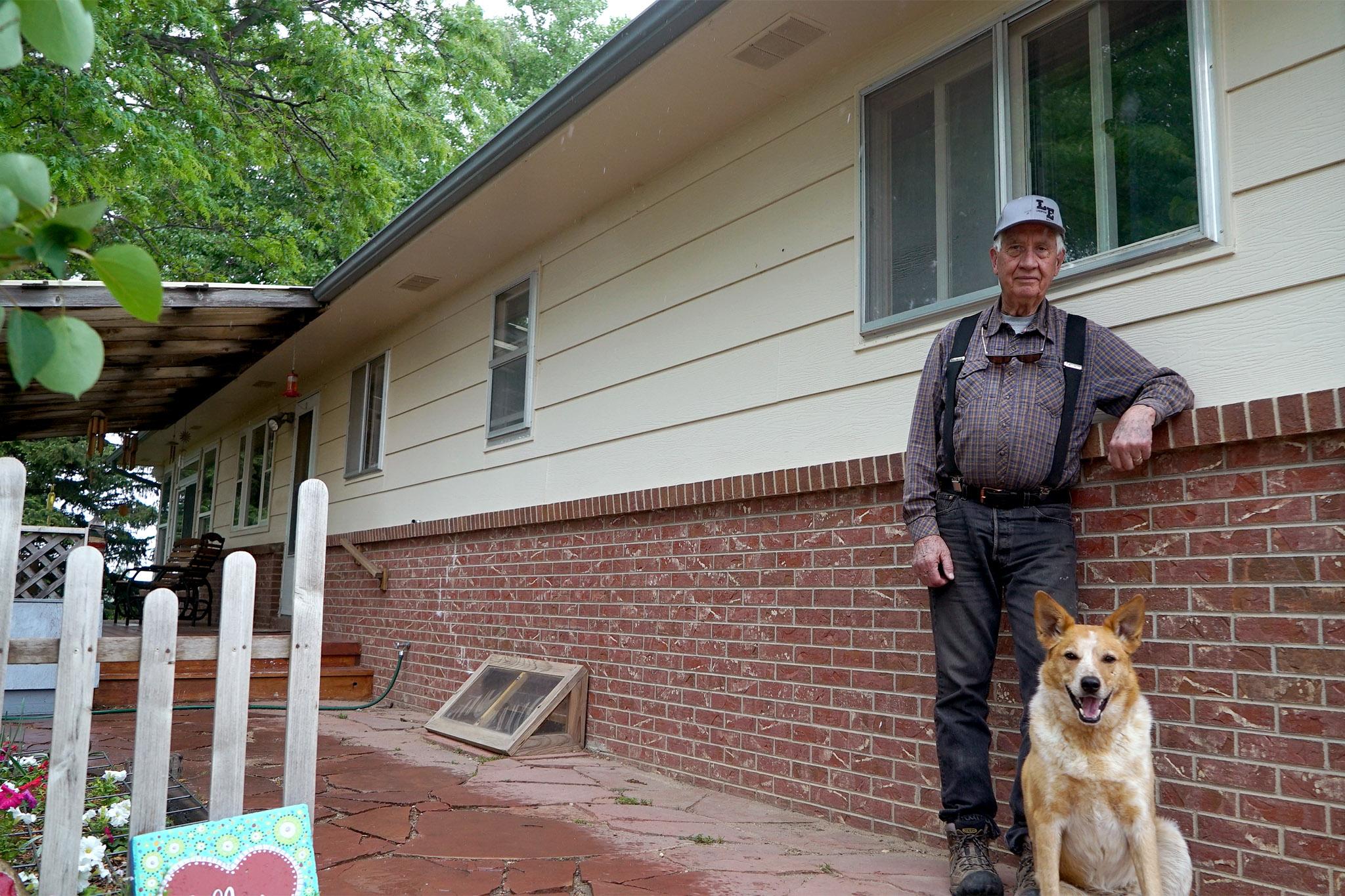 A man and his dog stand at their house near Galeton, Colorado.