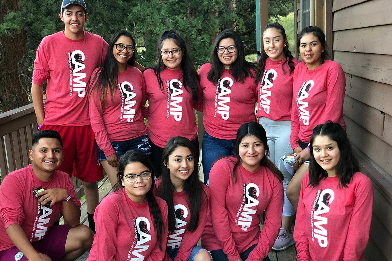 A group of people wearing red shirts with the word "Camp" on them, posing for a picture.