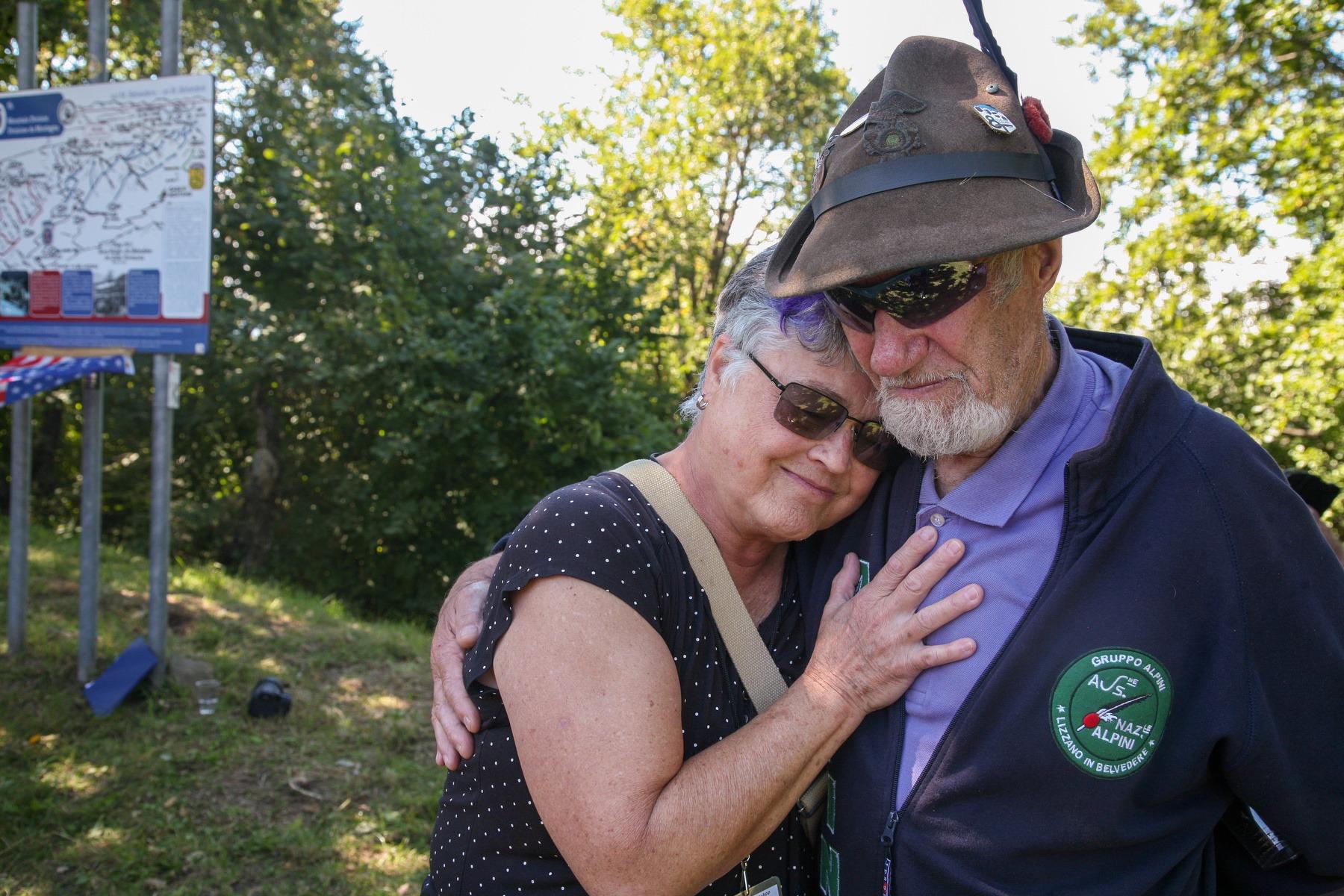 A man and women embrace on a mountain top.