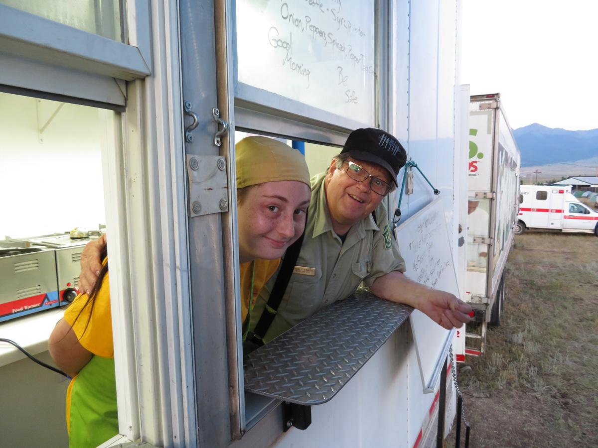 Job Corps student Samantha Oliver and instructor Chuck Steinberg help prepare meals for firefighters working the Hayden Pass Fire.