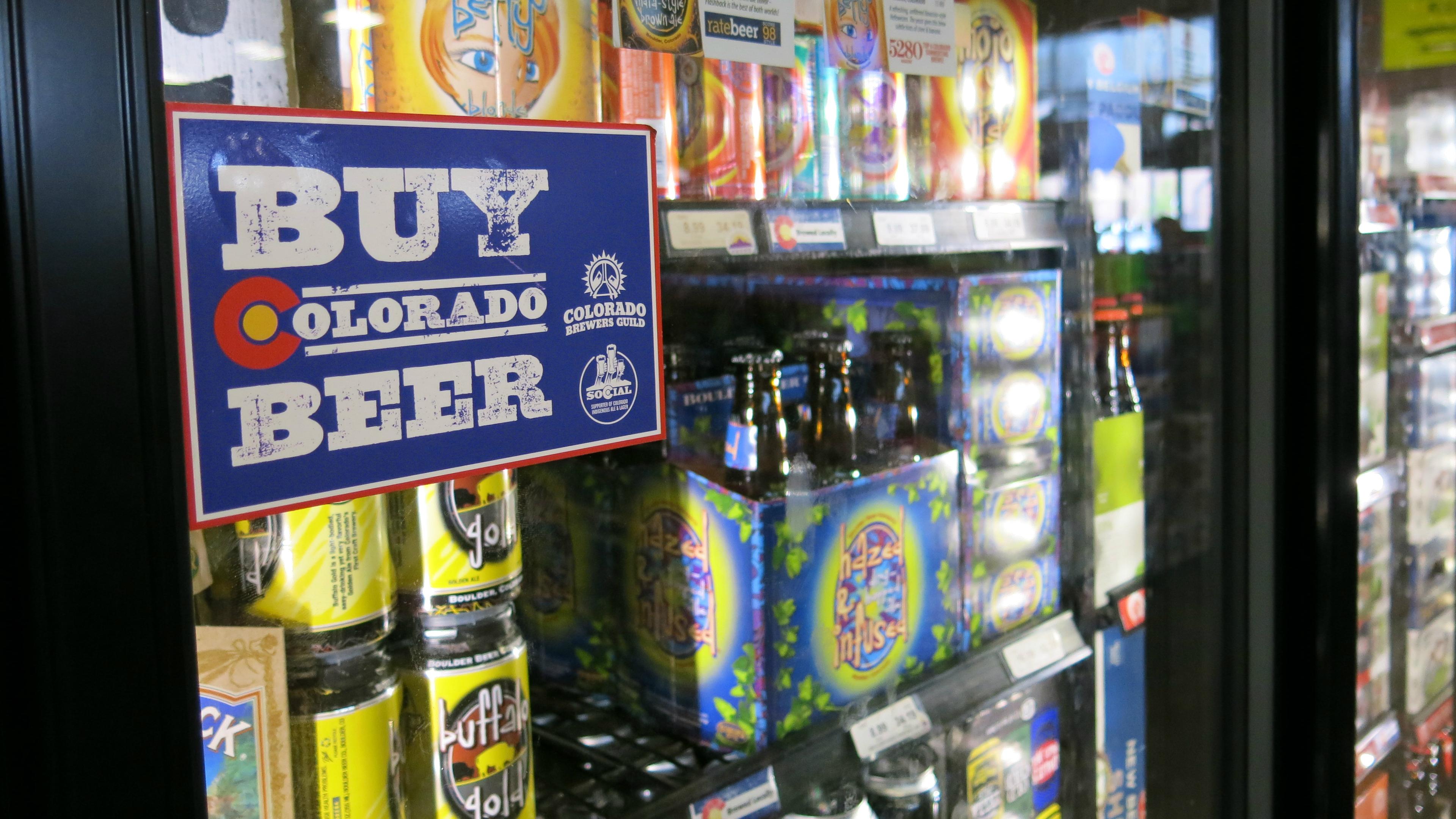 Hundreds of beers fill the coolers with a sign that says Buy Colorado Beer