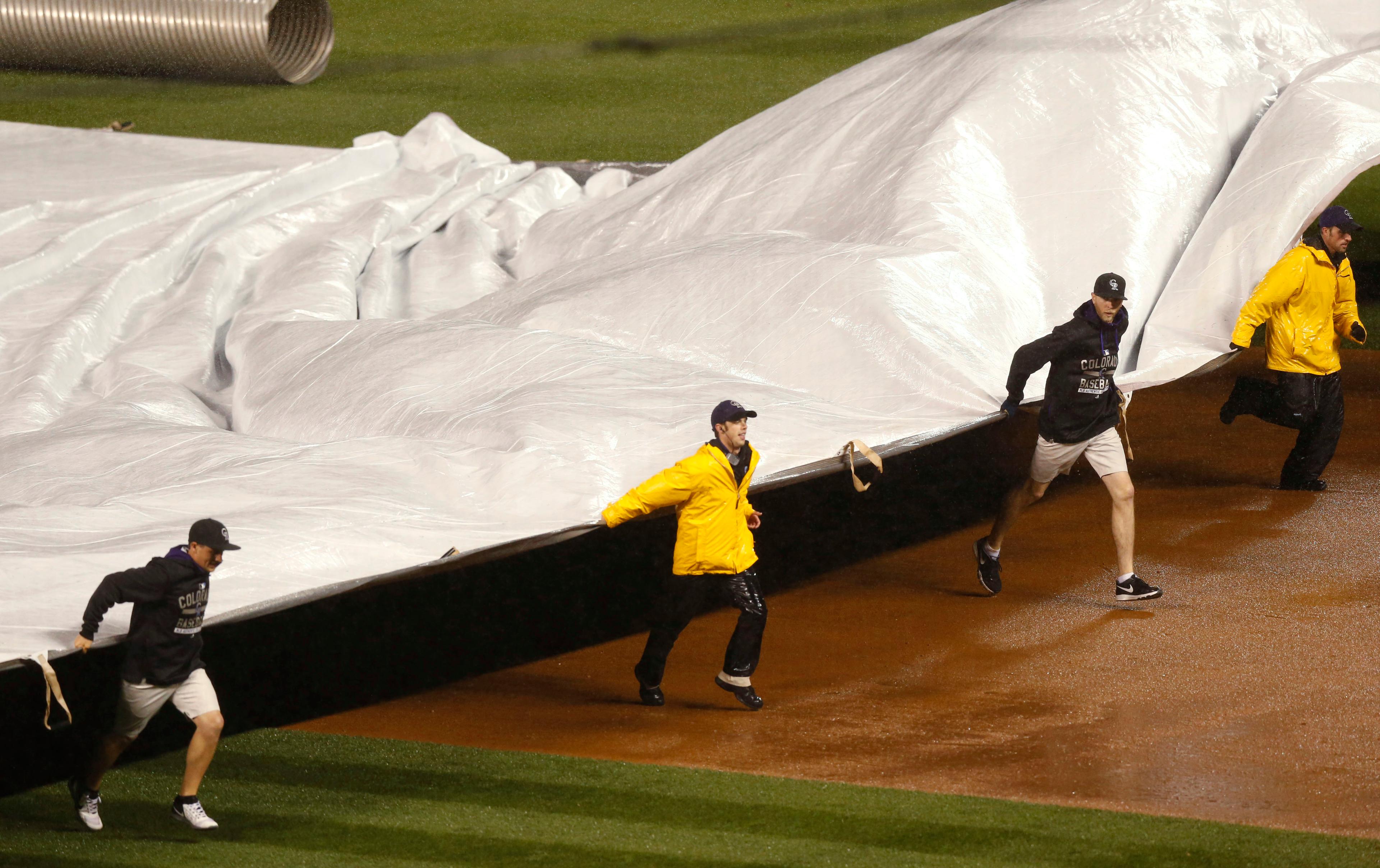 Grounds crew pull tarpulin