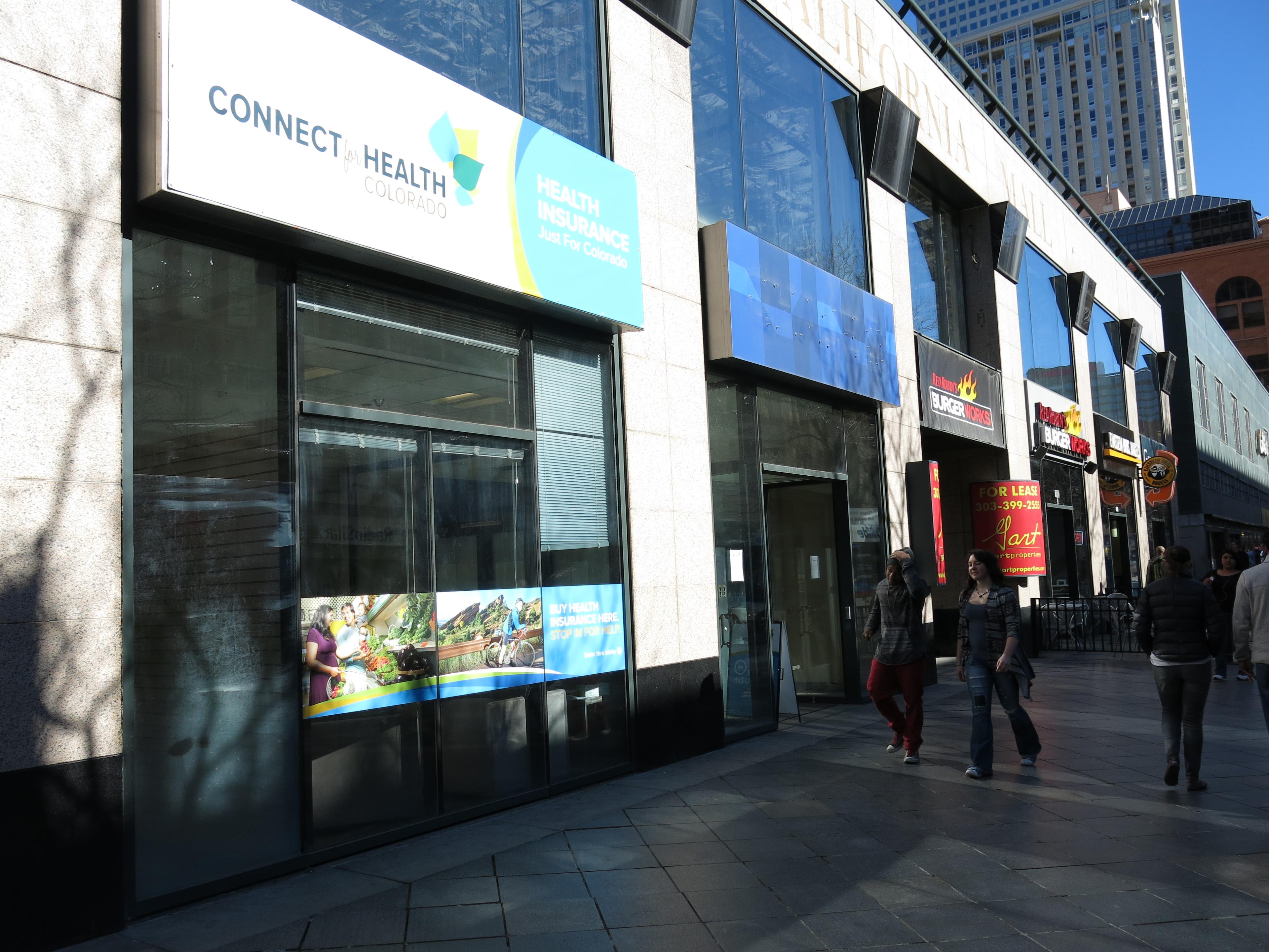 Sign that reads Connect for Health is on the first story of a building on a sunny day.