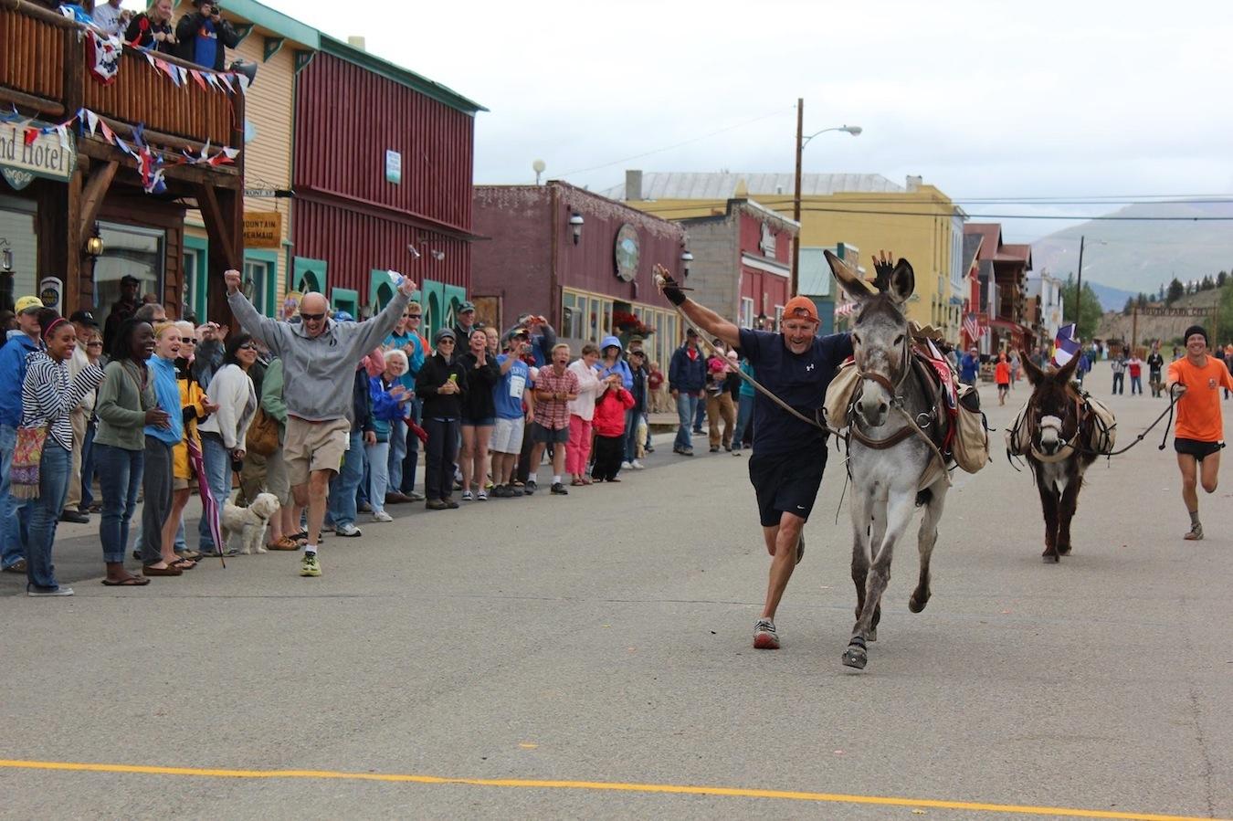 Hal Walter crosses the finish line with his burro Full Tilt Boogie to win 28.6-mile World Championship Pack Burro Racing Championship in Fairplay in 2013.