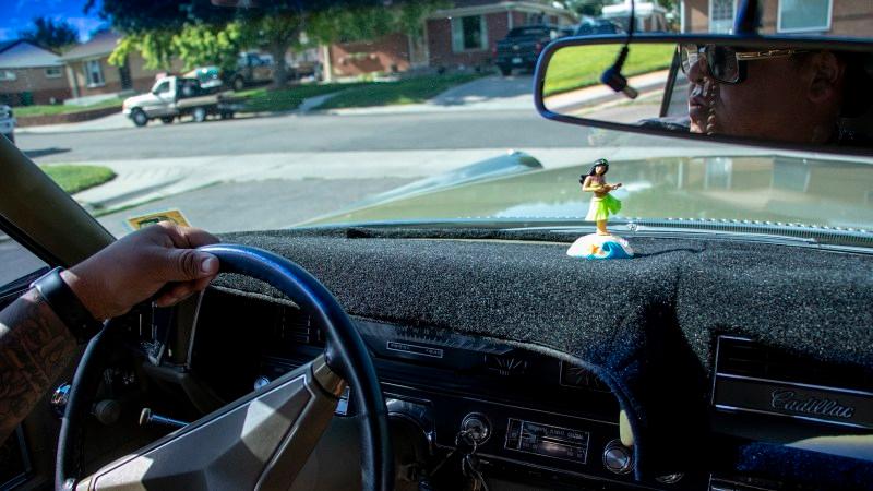 Ben Chavez gives a guy a ride in his Cadillac around the Twin Lakes block where he lived as a kid. Aug. 14, 2019.