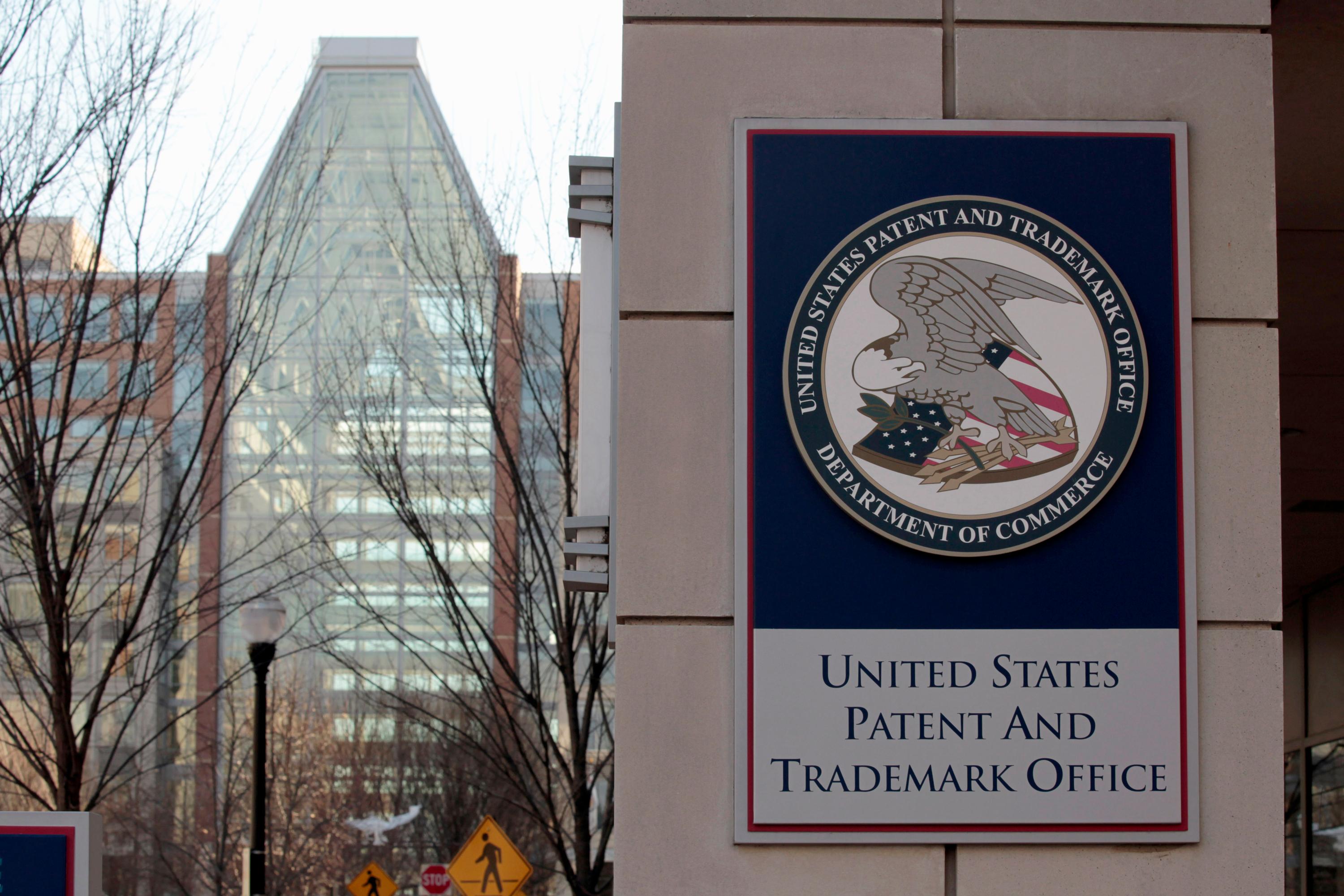 A sign with the United States Patent and Trademark Office logo is displayed on a building.