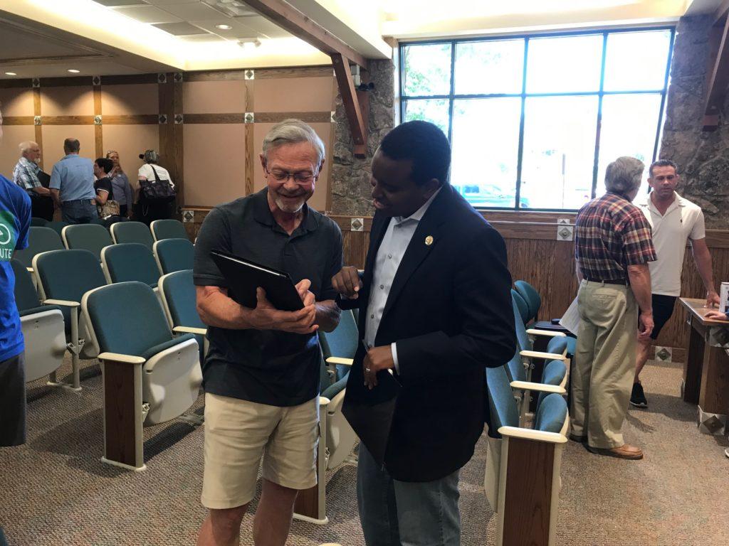 Rep. Joe Neguse speaking with Estes Park resident Richard Mulhern at the end of a town hall.
