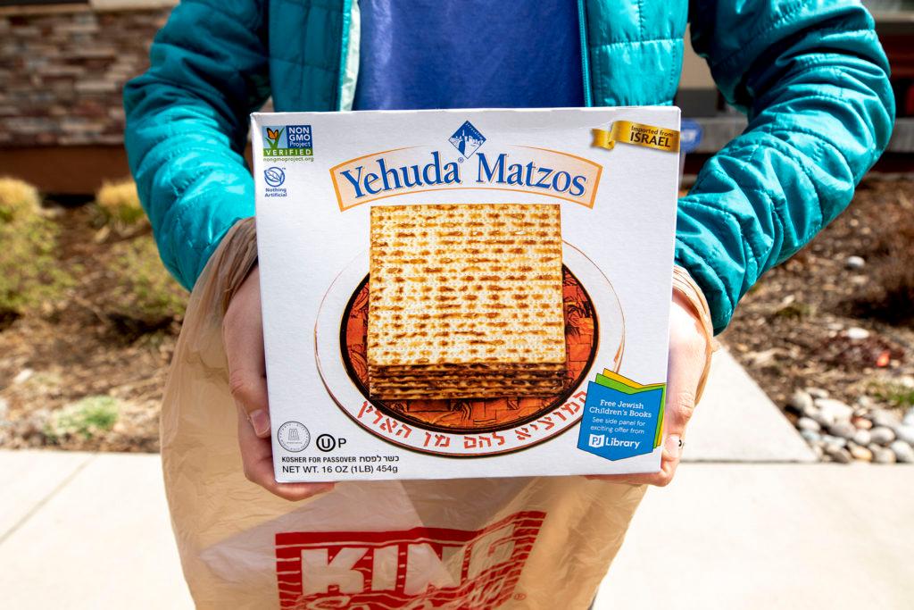 Sadie Ladis holds up some Yehuda Matzos for Passover that she's delivering to a fellow member of Temple Micah, who can't leave the house during the COVID-19 outbreak on April 3, 2020.