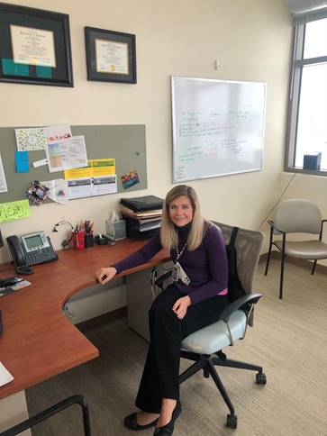 A picture of Andrea Rehmert at her desk in the VA.