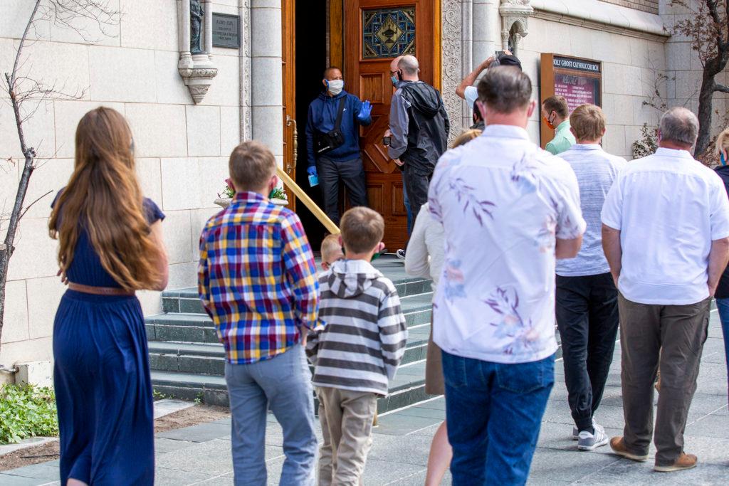Parishoners wait to enter Holy Ghost Catholic Church in small, socially distant groups. May 9, 2020.
