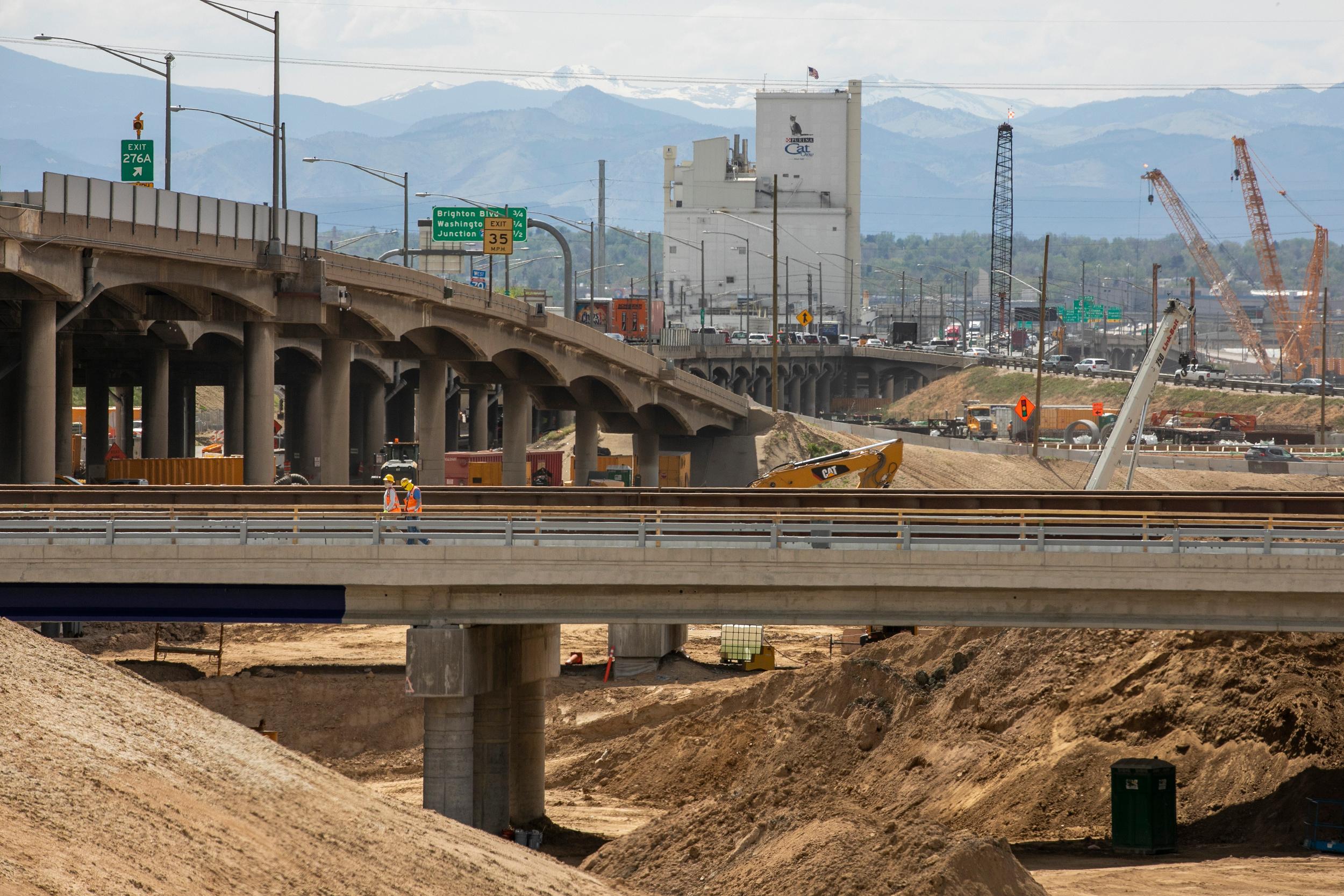 A road crew picks up safety cones after repaving work on East 13th Avenue in Denver