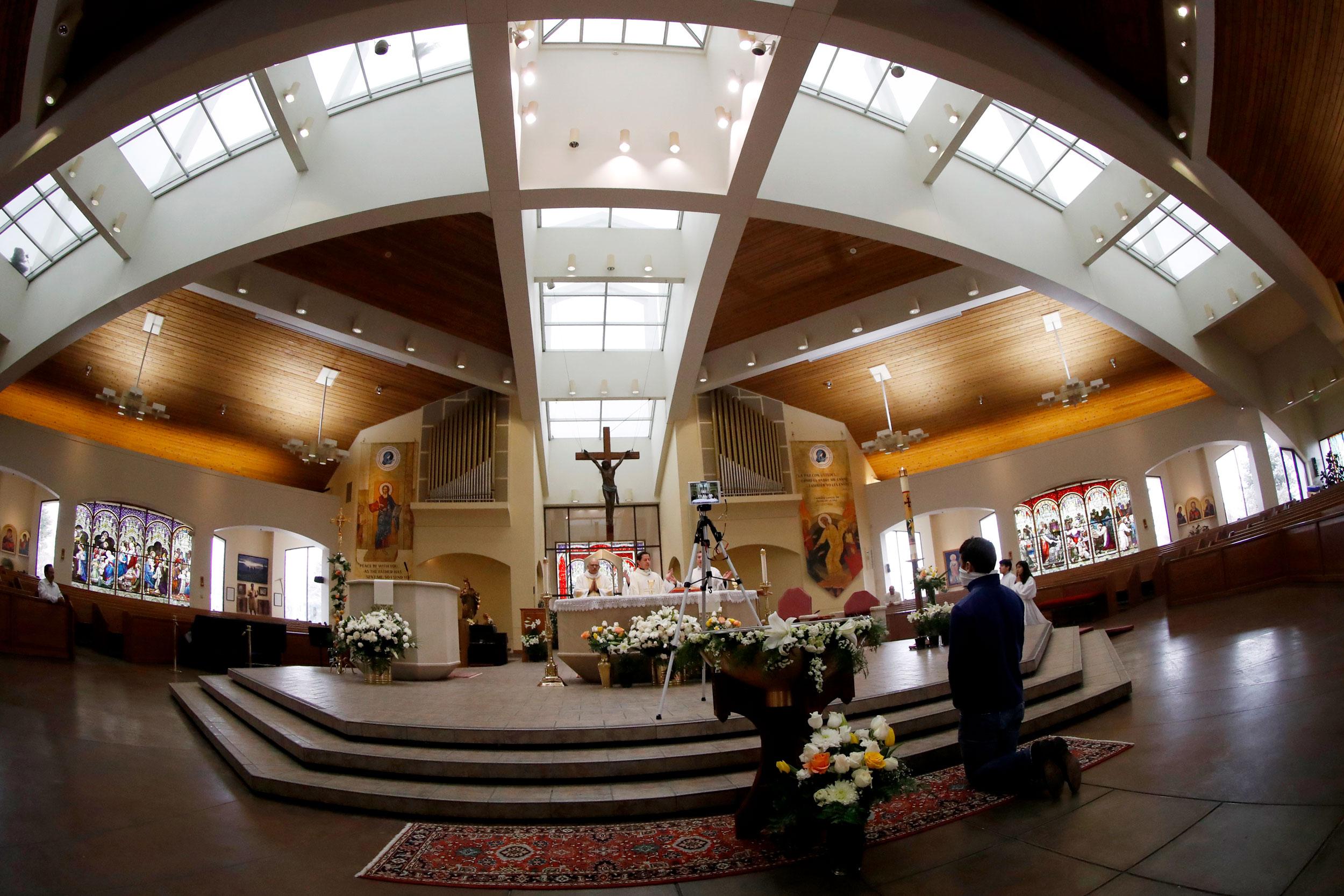 From left, Deacon Efra Pruneda, Father Jesus Murillo and Father Felix Medina deliver Easter Mass in Spanish during a broadcast of services because of the new coronavirus Sunday, April 12, 2020, in Queen of Peace Catholic Church in Aurora, Colo.