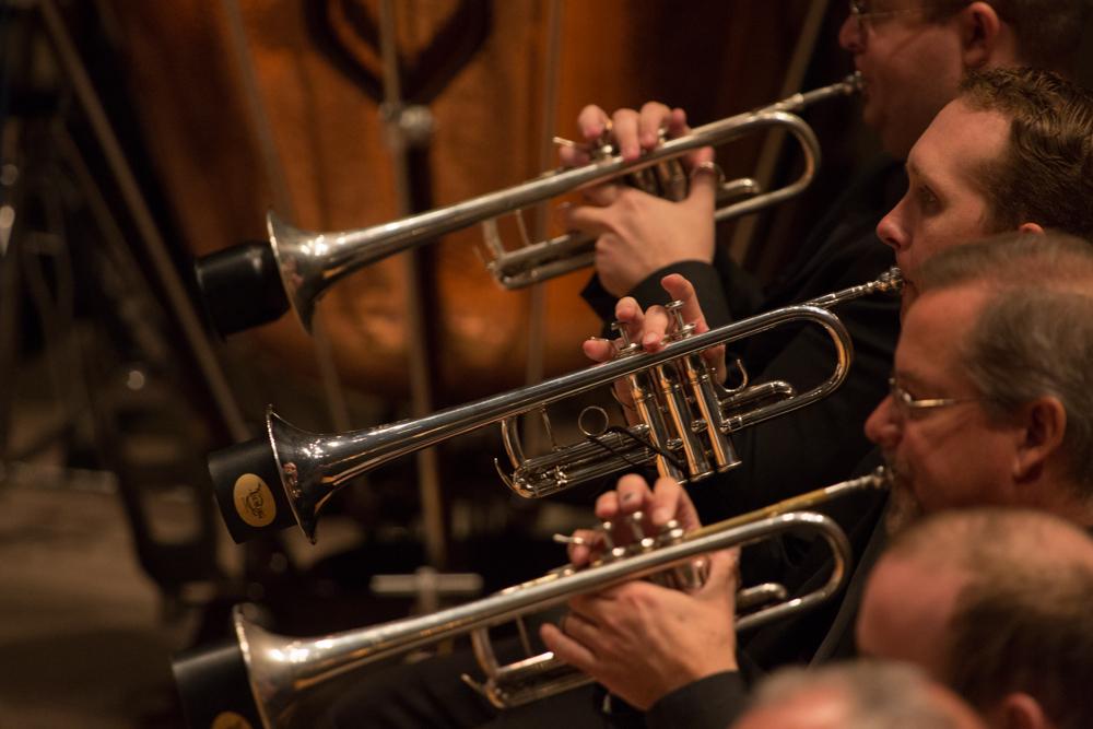 3 trumpet players in profile in the midst of the Colorado Symphony Orchestra