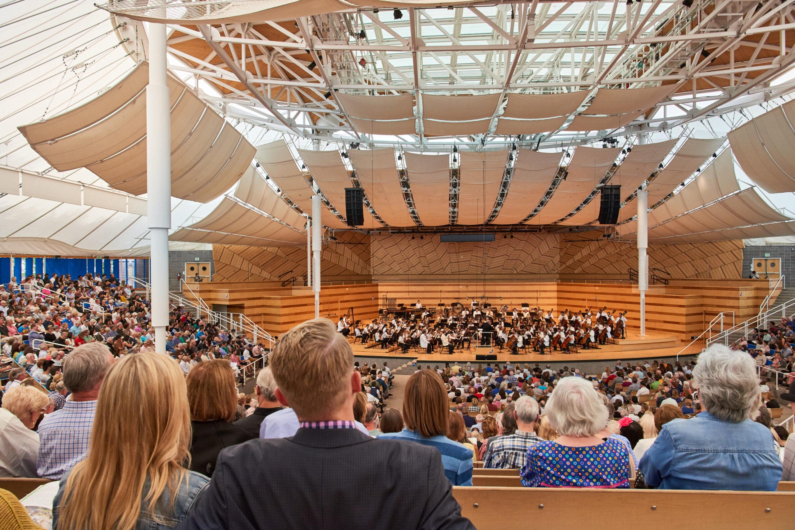 A full audience watching a performance during the Aspen Music Festival in an open-air amphitheater.