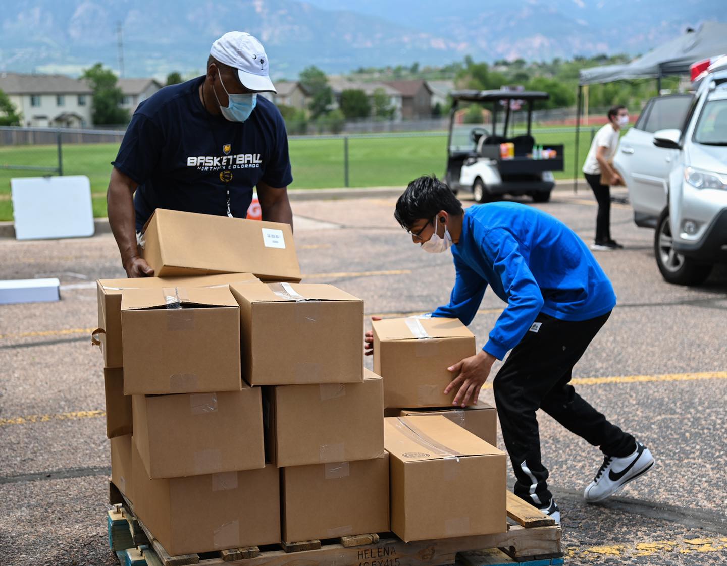 A photo of two volunteers for Care and Share loading boxes of food.