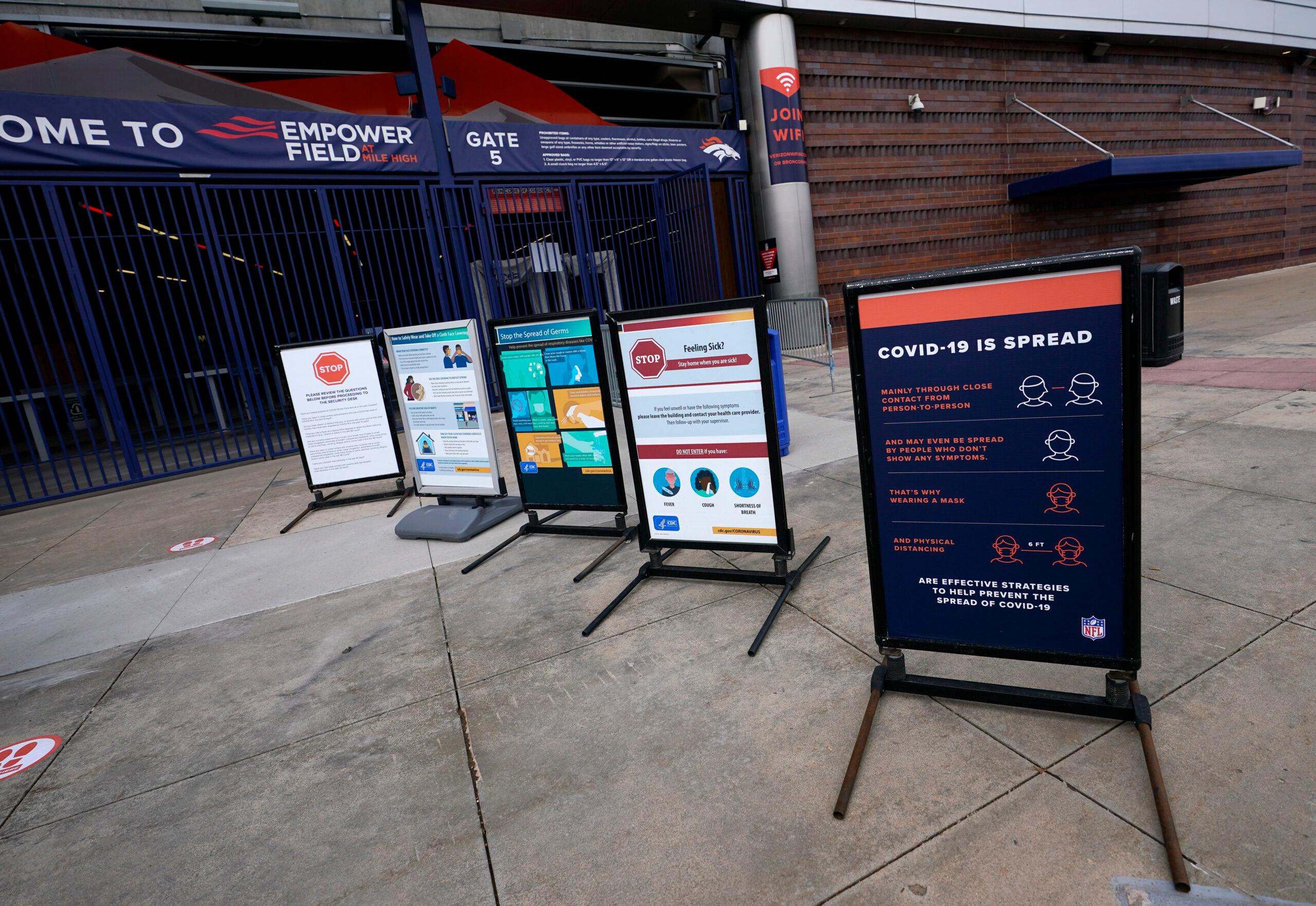 COVID-19 warning signs outside Empower Field at Mile High.