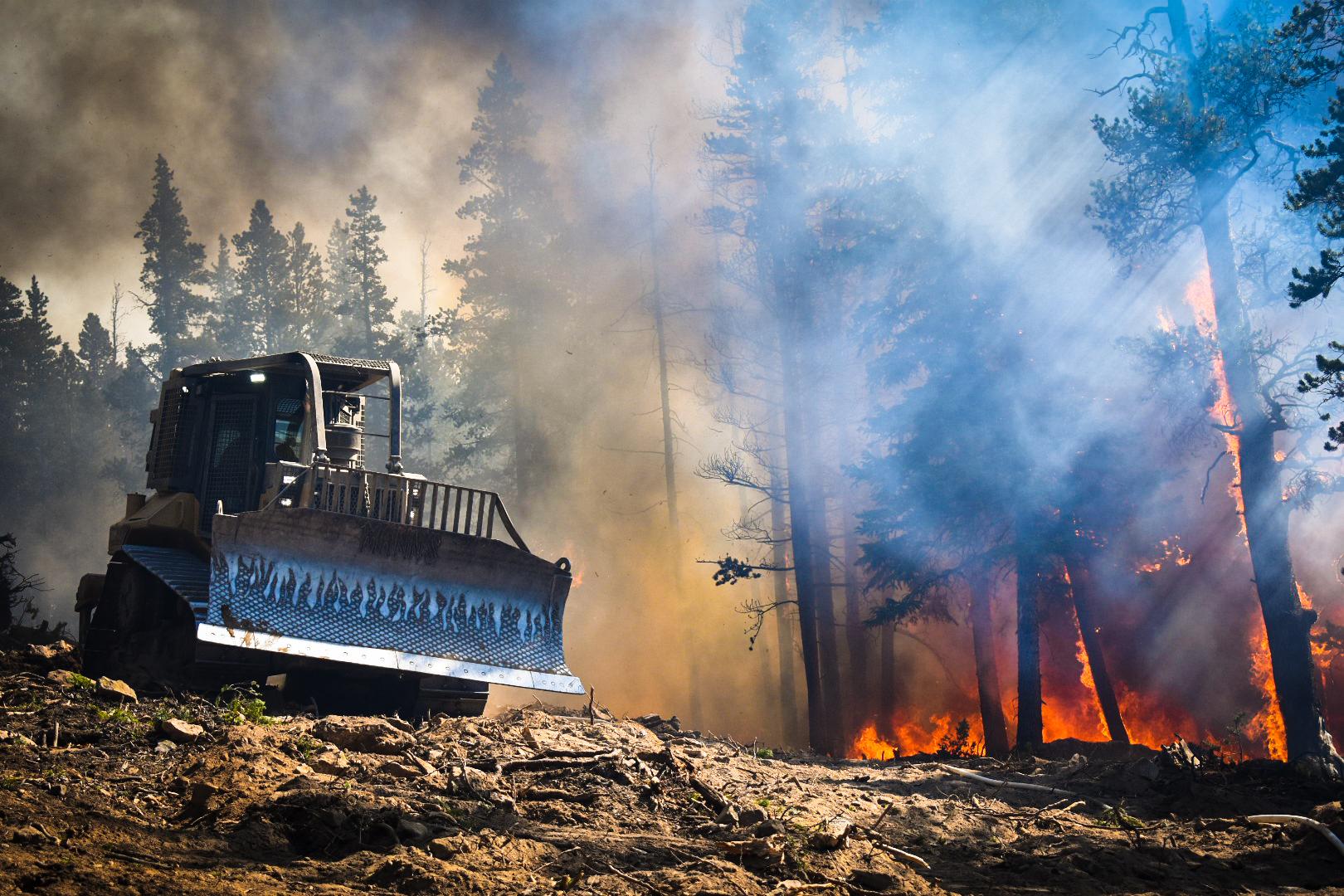 A bulldozer drives along a perimeter near the Cameron Peak Fire west of Fort Collins.