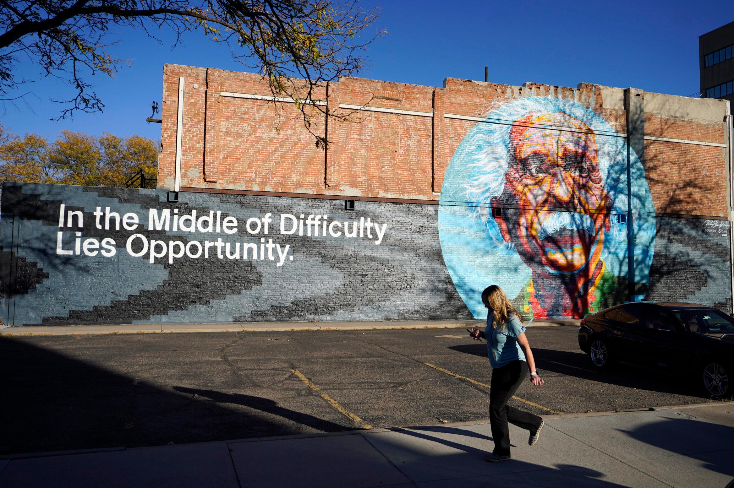 A pedestrian moves past a mural of Albert Einstein in Greeley.