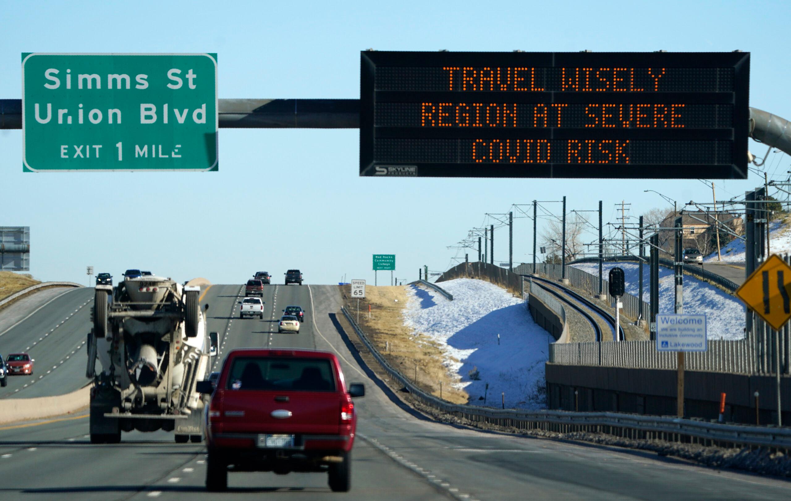 Highway sign warns of high COVID-19 risk in Colorado.