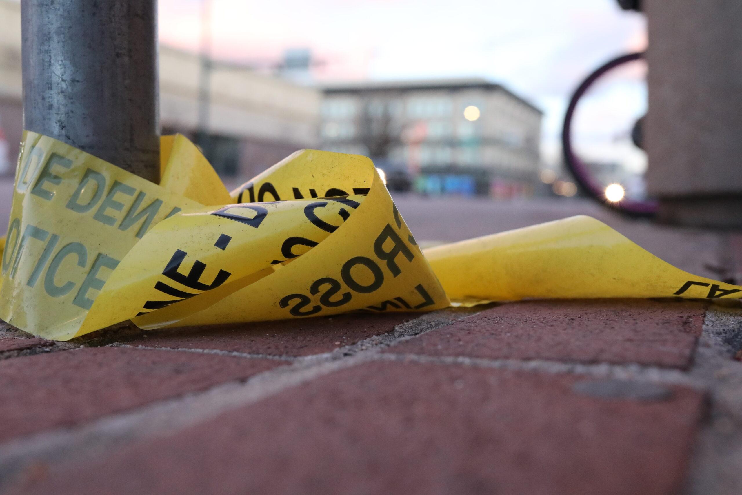 Police tape lies on the ground at 1st Avenue and Broadway in Denver after a shooting nearby on Monday, December 27, 2021.