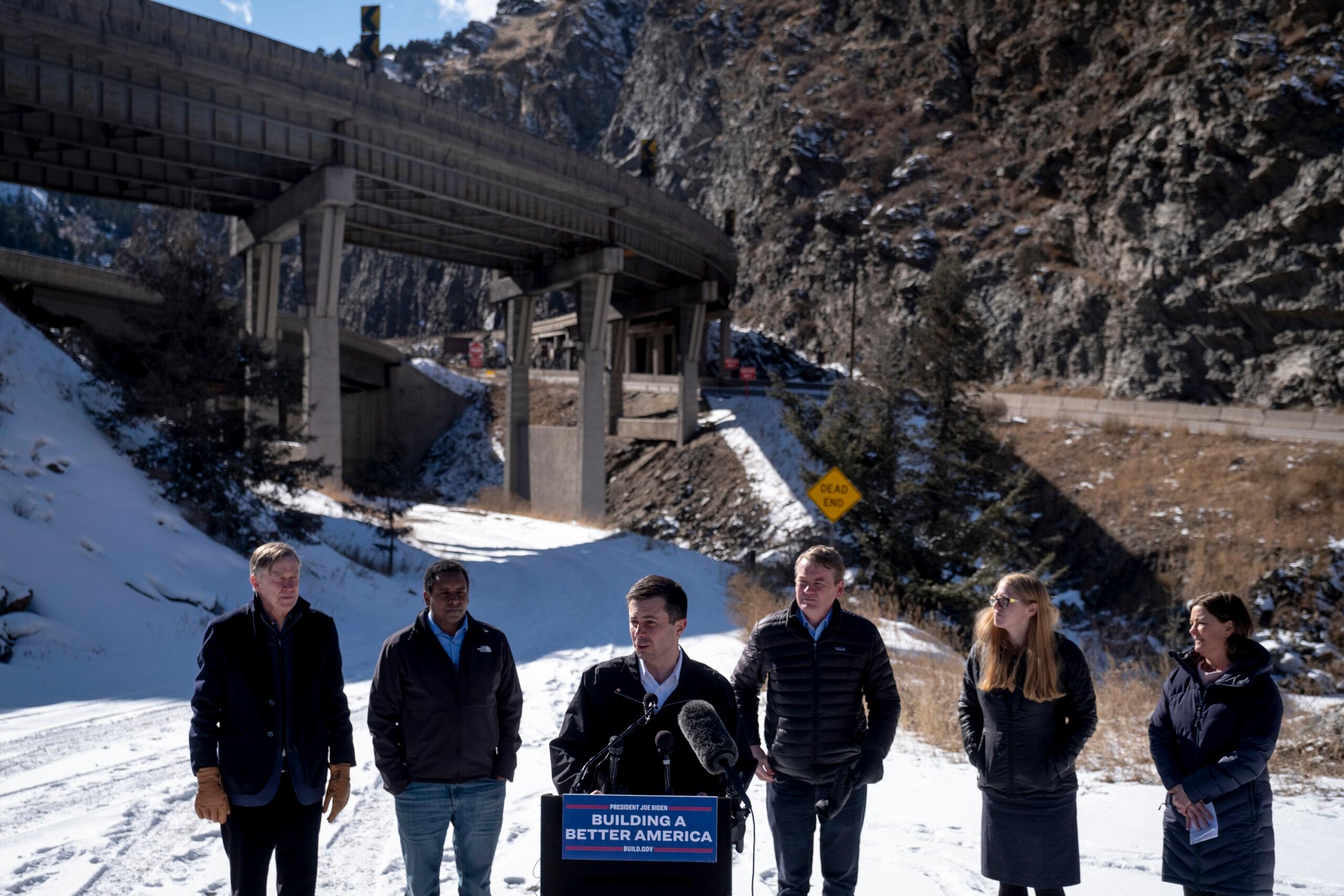 U.S. Transportation Sec. Pete Buttigieg discusses an Interstate 70 expansion project at Floyd Hill during a press conference with other Colorado leaders in Idaho Springs on Thursday, February 24, 2022. From left, Sec. Buttegieg is accompanied by Sen. John Hickenlooper, Rep. Joe Neguse, Sen. Michael Bennet, Colorado Department of Transportation executive director Shoshana Lew, and I-70 Coalition director Margaret Bowes. Gov. Jared Polis later joined.