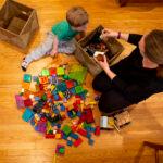 Beatrice Scheuermann and her son, Hans, play on the floor in their Congress Park home. March 22, 2022.