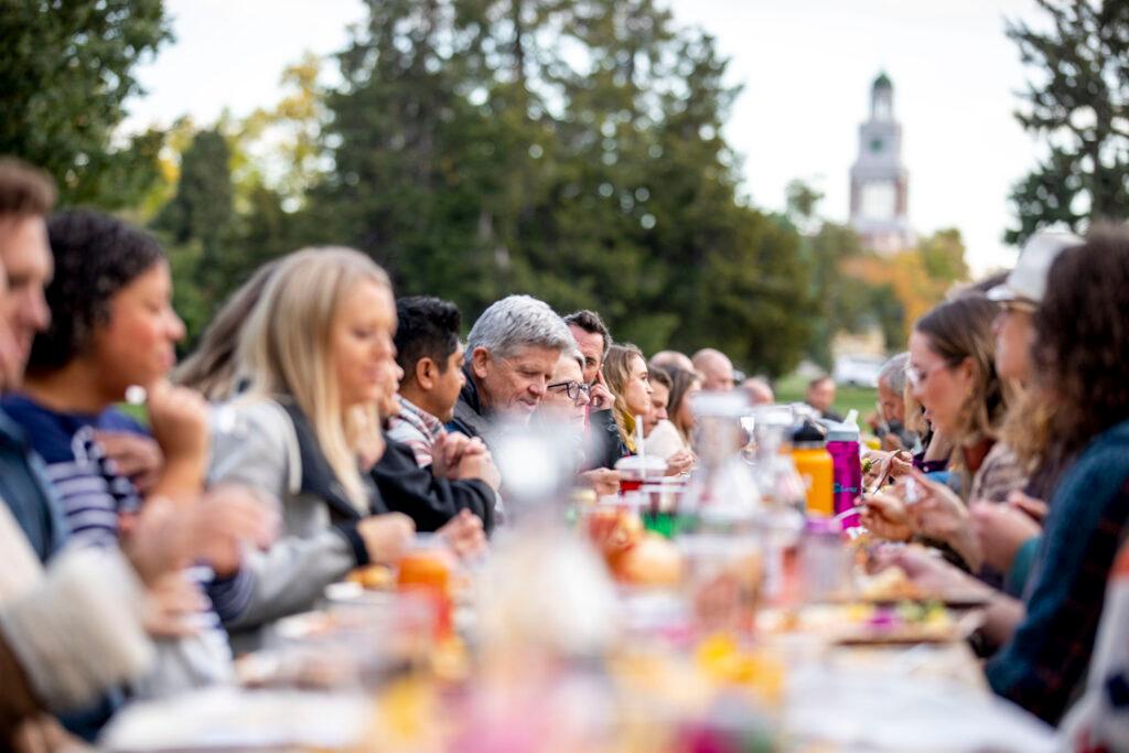 Guests gather for dinner at a long table dinner at City Park. Oct. 15, 2022.