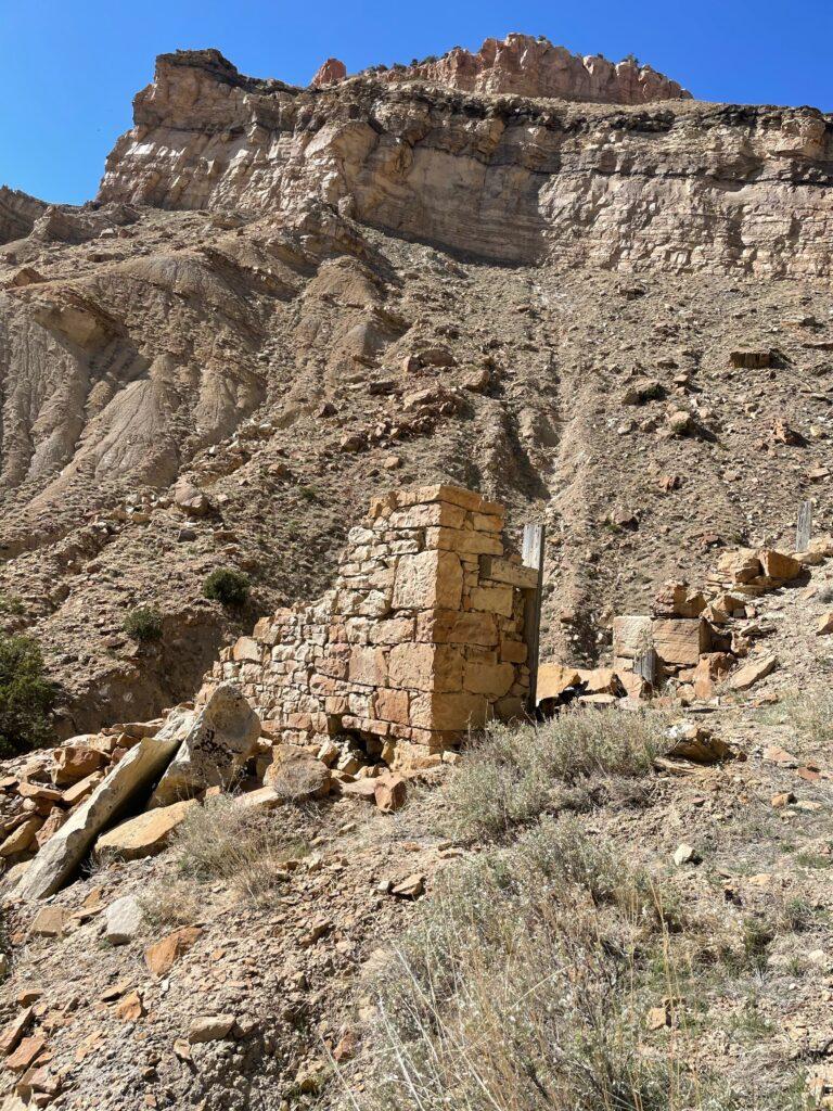 A crumbling pillar made of stones that once was the corner of a building.