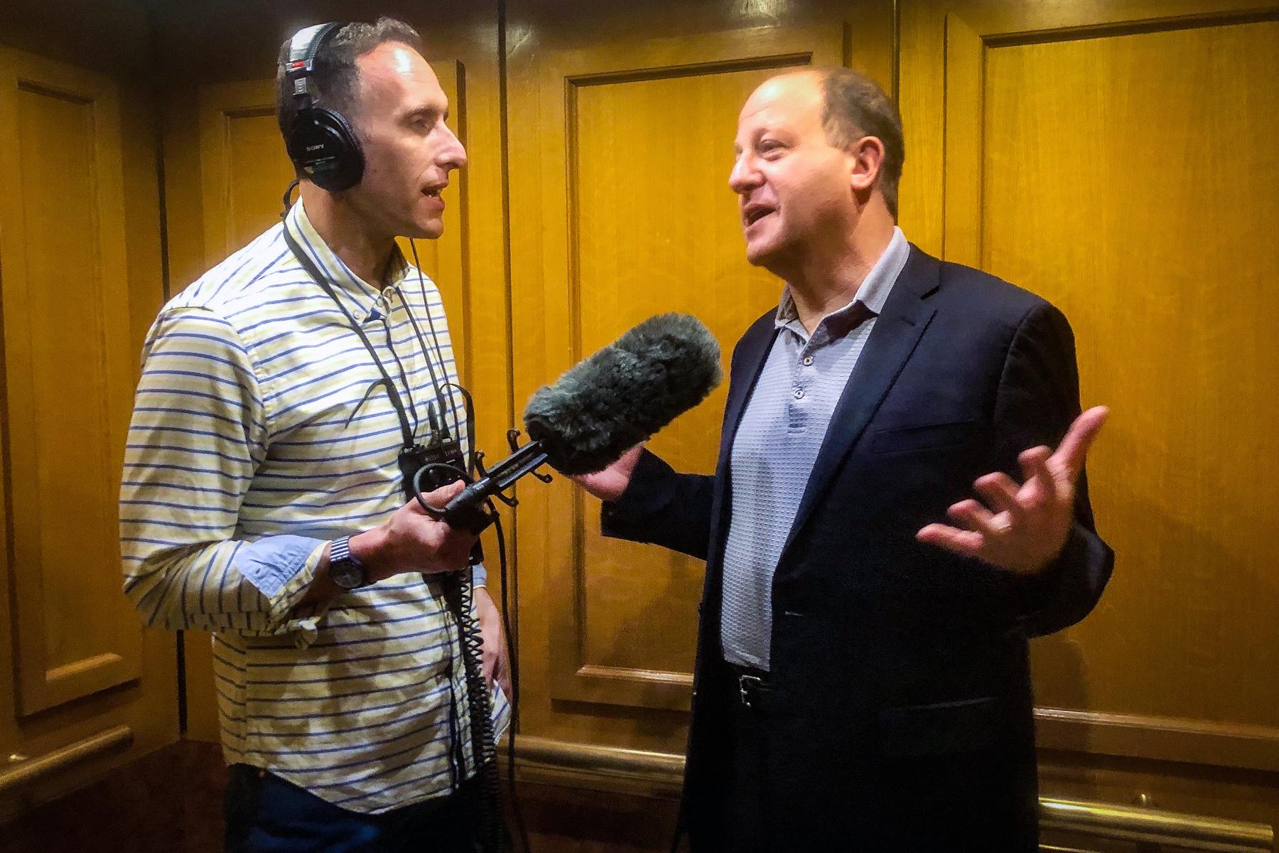 Gov. Jared Polis gives is elevator pitch to Colorado Matters host Ryan Warner in the Capitol elevator, Tuesday, June 13, 2023.