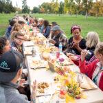 Guests gather for dinner at a long table dinner at City Park. Oct. 15, 2022.