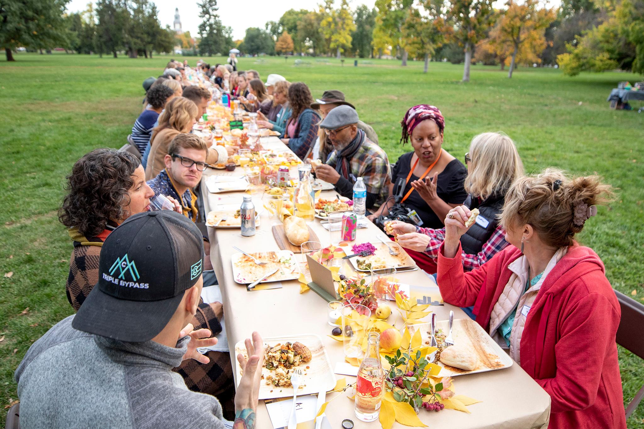 Guests gather for dinner at a long table dinner at City Park. Oct. 15, 2022.