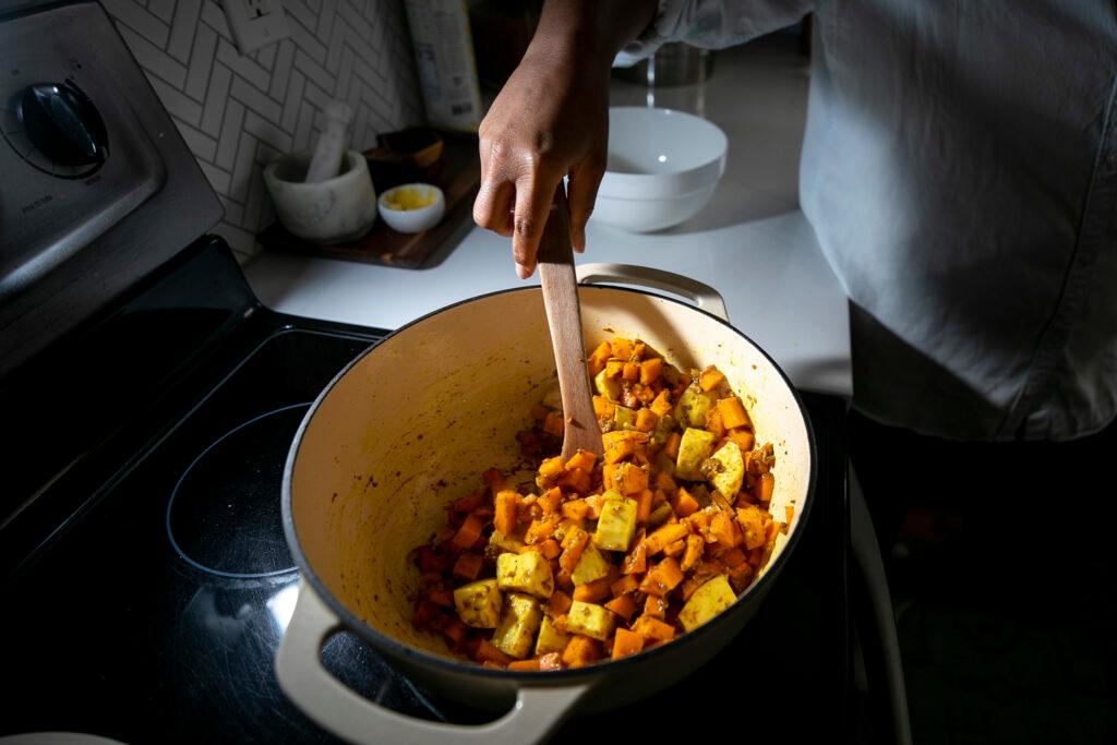 Althea Brown cooks up a pumpkin curry in her Aurora home. Dec. 13, 2023.