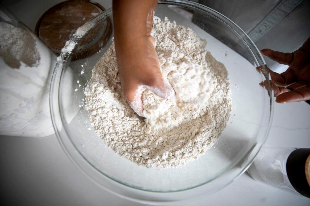 Althea Brown kneads flour into roti dough in her Aurora home. Dec. 13, 2023.
