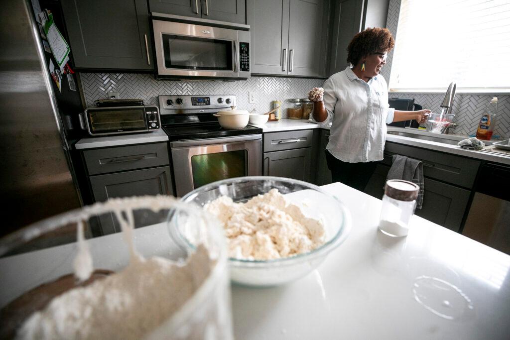 Althea Brown kneads roti dough in her Aurora home. Dec. 13, 2023.