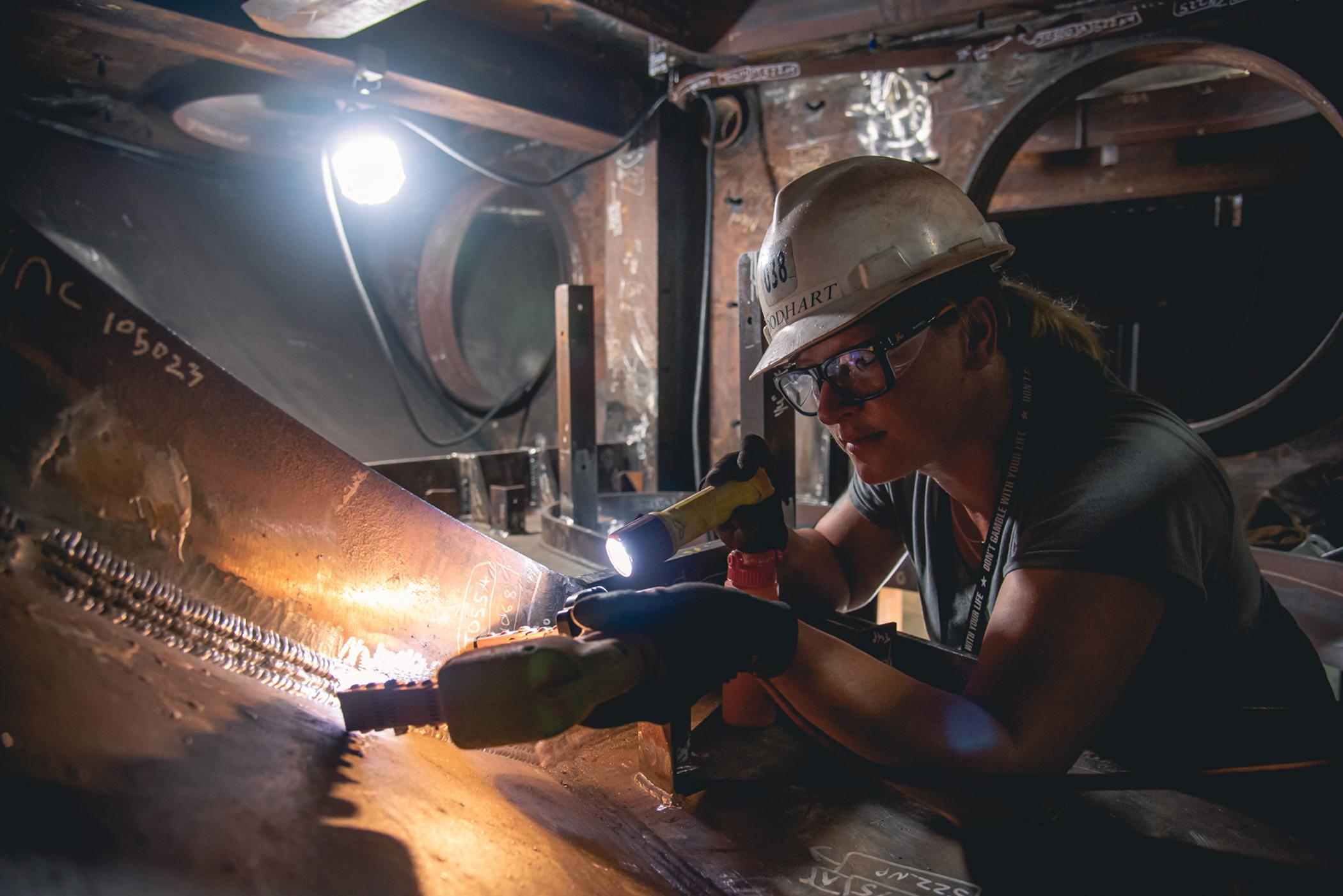 Female Inspecting Weld on Arizona SSN 803 Sonar System