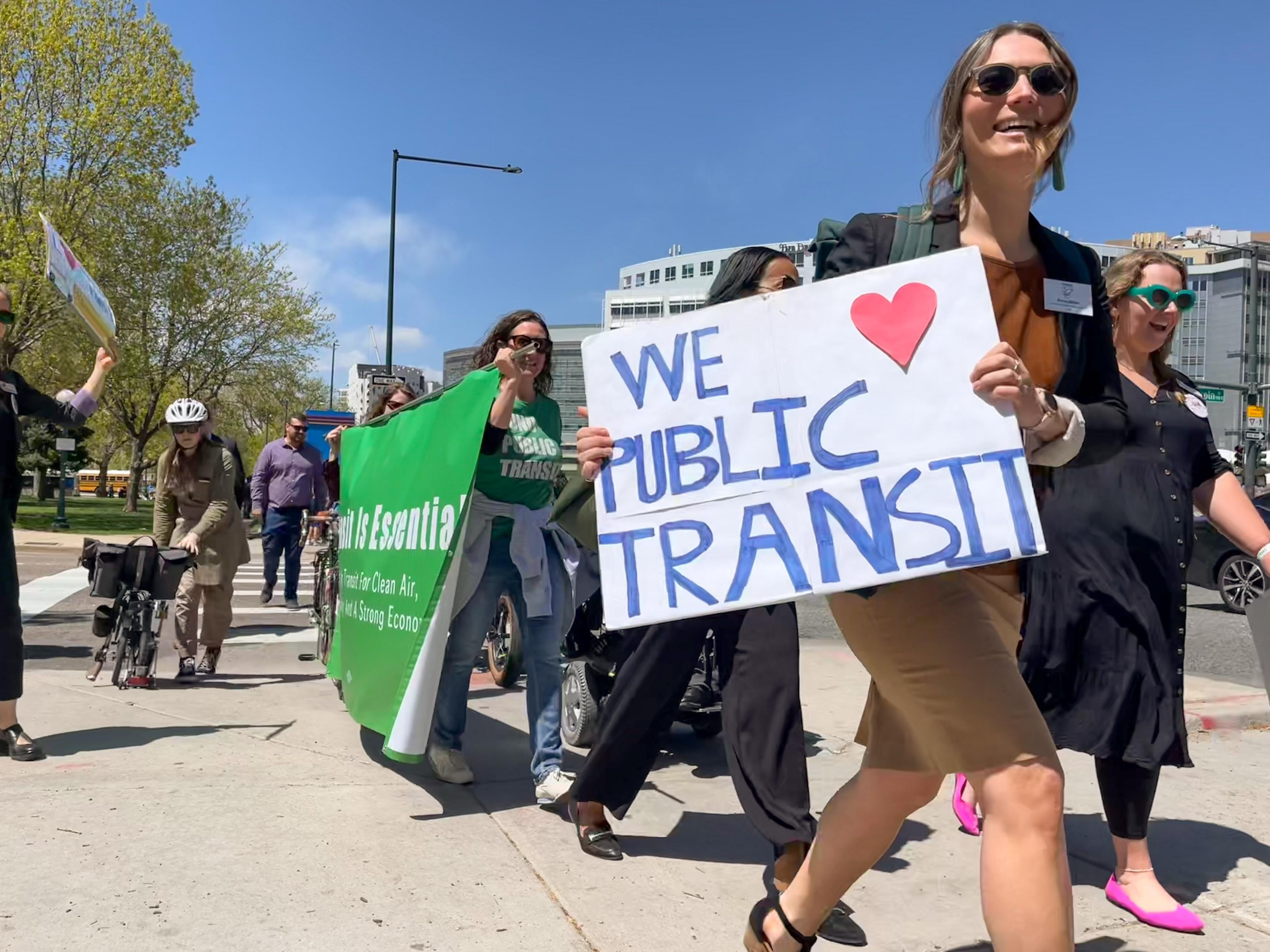 Public transit supporters carrying signs supporting air pollution bill that funds for RTD.