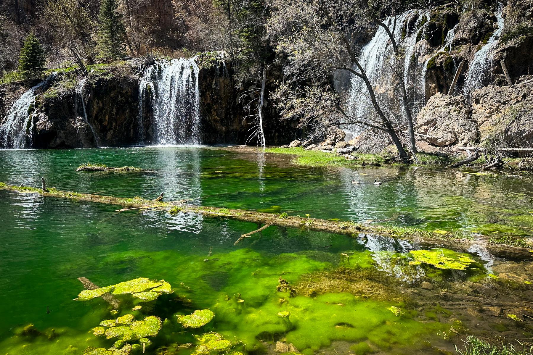 Waterfalls drop into a clear water of Hanging Lake