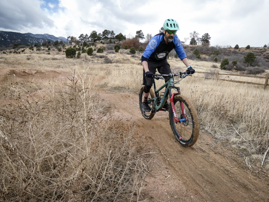 Cory Sutela, leader of Medicine Wheel Trail Advocates, a mountain bike trails organization in the Pikes Peak Region, riding his bike on a dirt trail.