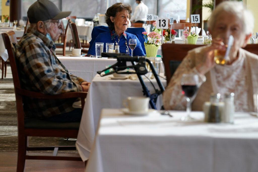 Residents dine together in the dining hall at an independent senior housing facility,