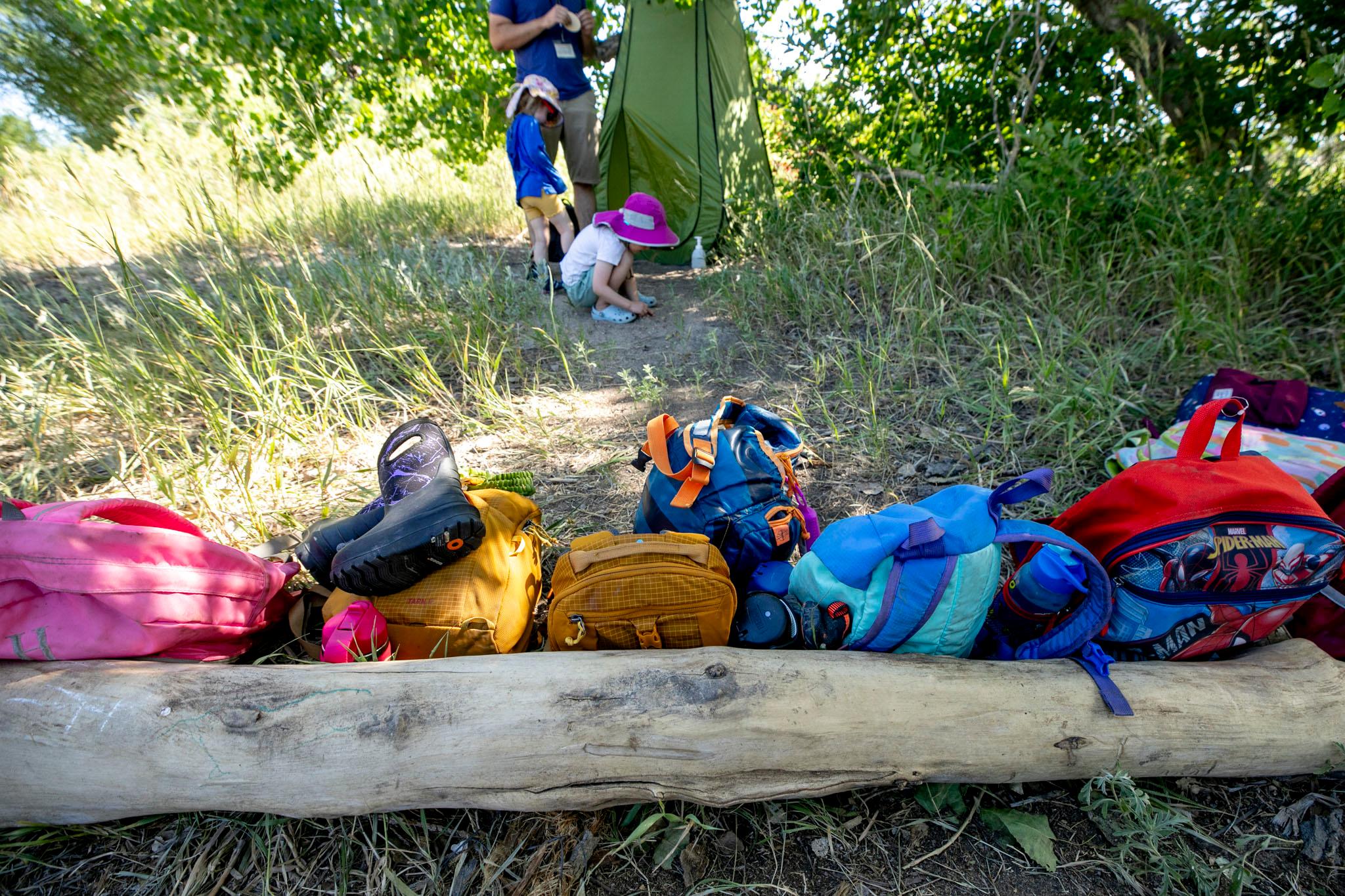 Backpacks in a line by the Cherry Creek