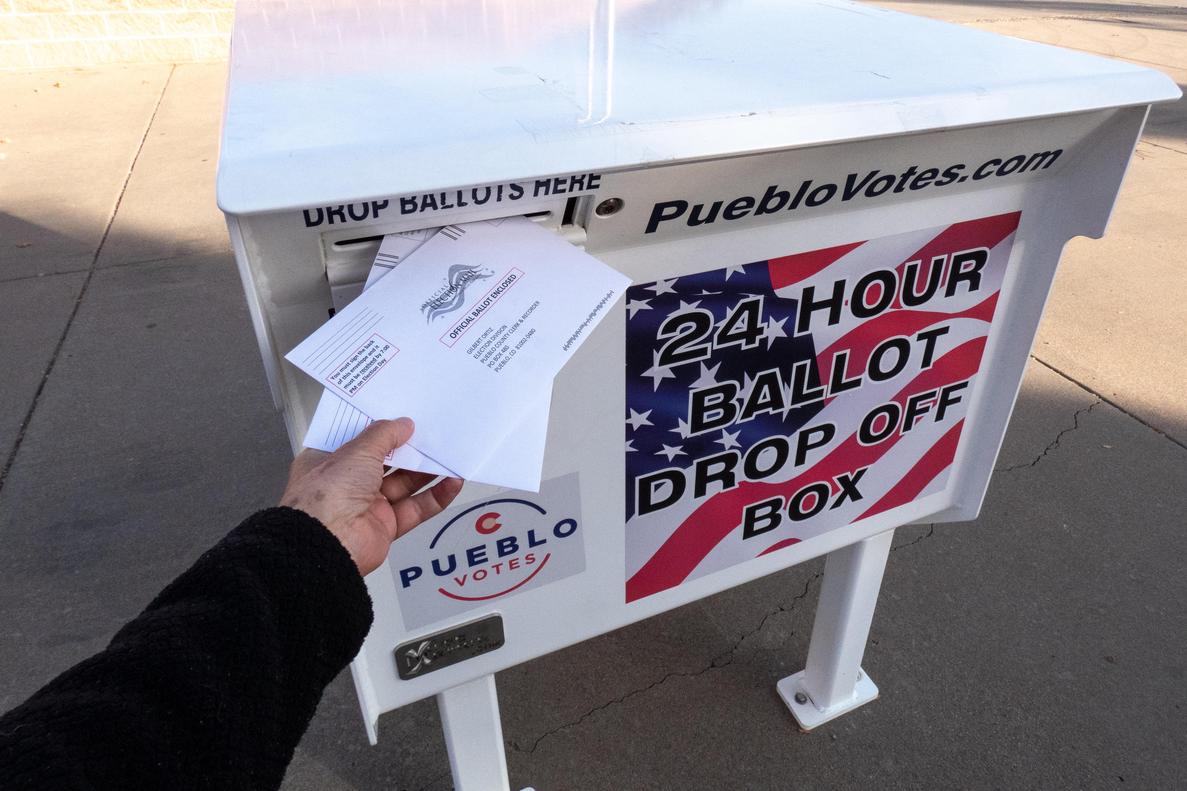 ballots being placed into a ballot box