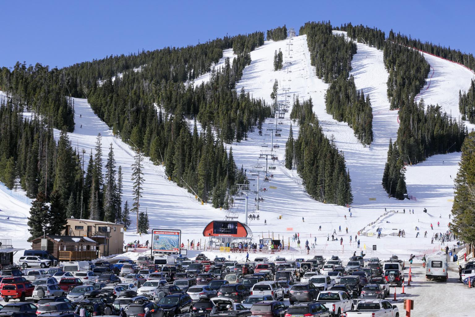Full parking lot and skiers on a lift at Eldora Mountain Resort