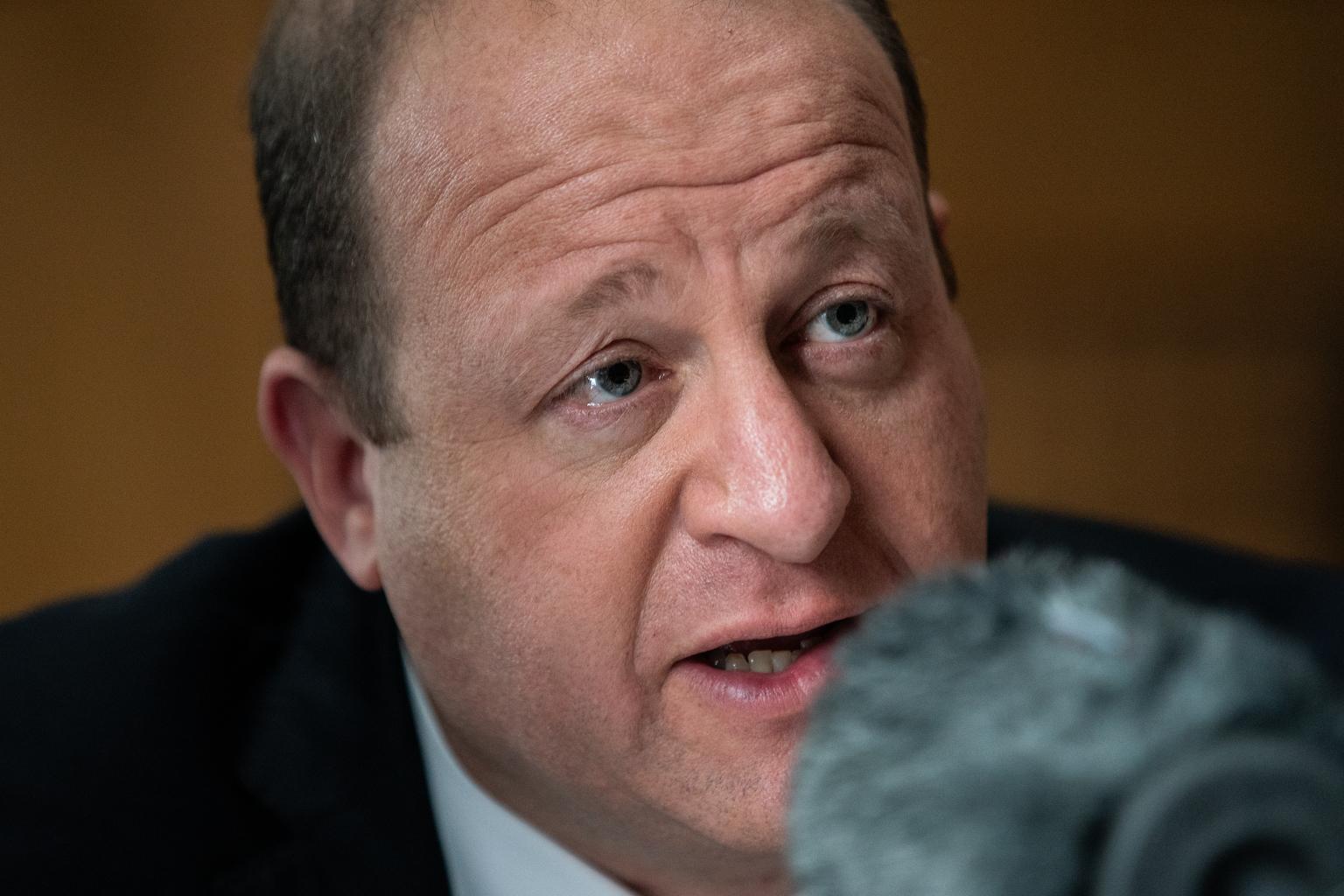 Jared Polis speaks with reporters after the State of the State address.