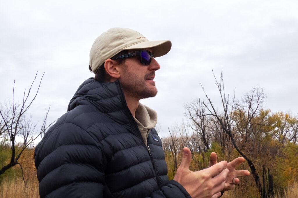 profile of a person wearing a baseball hat and puffer jacket