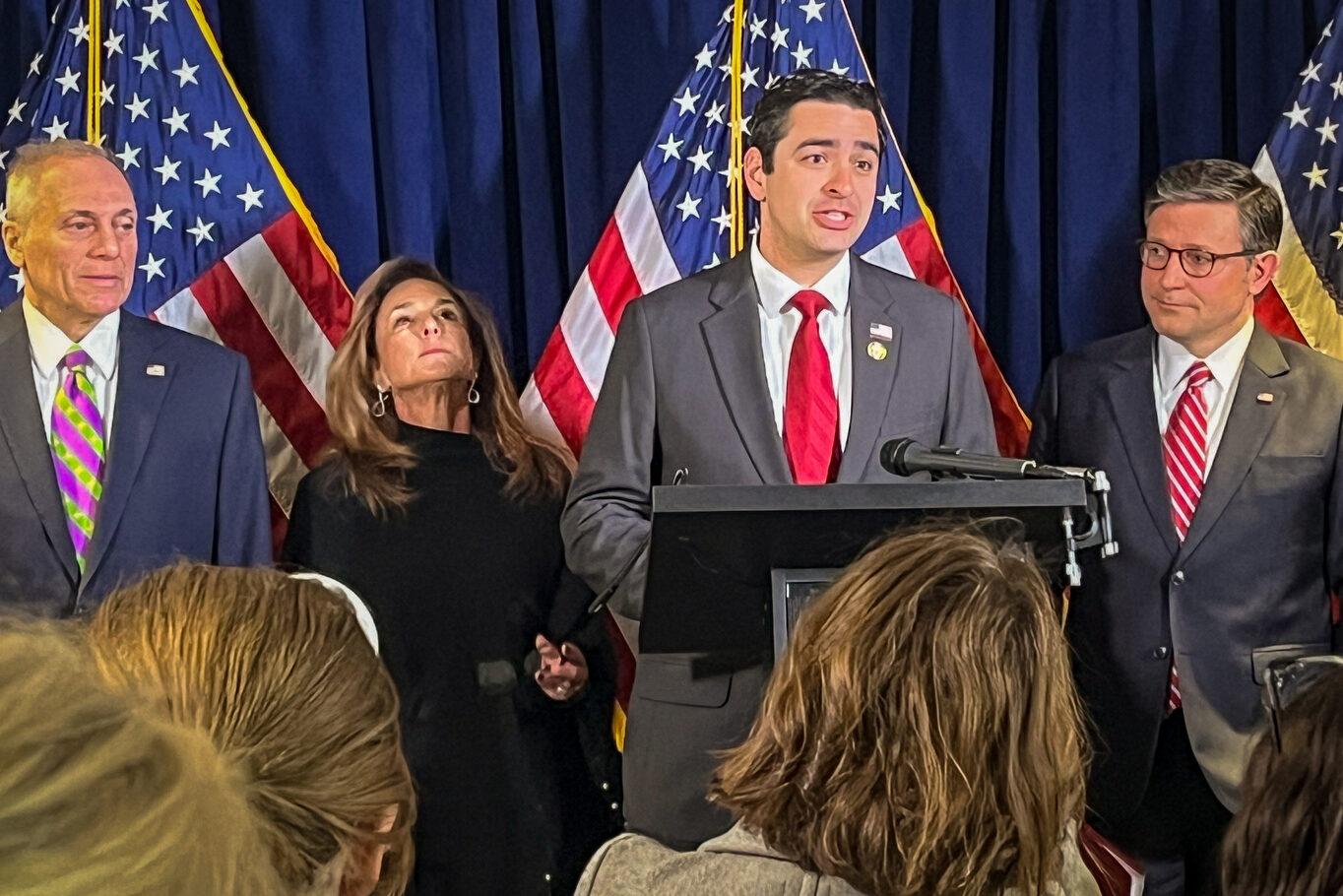 Rep. Gabe Evans, at left, listens as House Speaker Mike Johnson makes remarks at a press conference