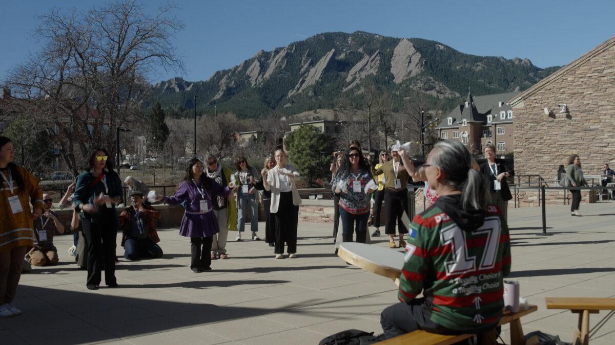 Indigenous community members lead a dance at a pavilion at the University of Colorado