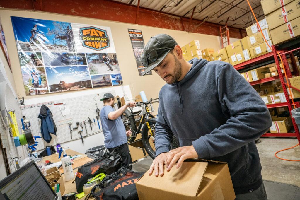 David Miller packs components to ship as Dakota Mossburg assembles a bike at Borealis