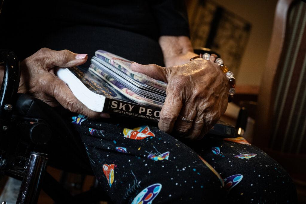 Wearing her flying saucer pants, Angela Lee holds a copy of the book “Sky People"