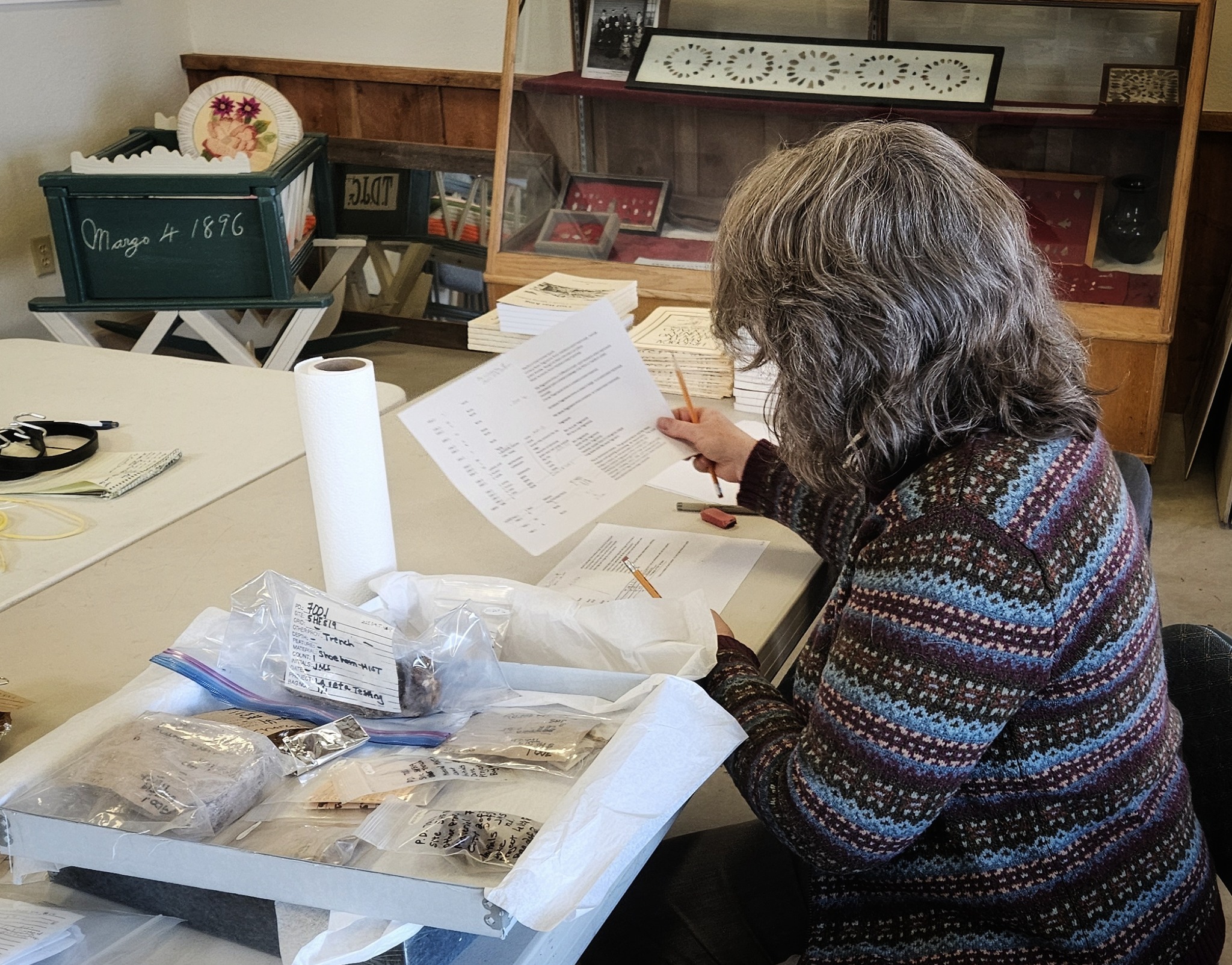 a person works at a desk with labeled plastic bags of items
